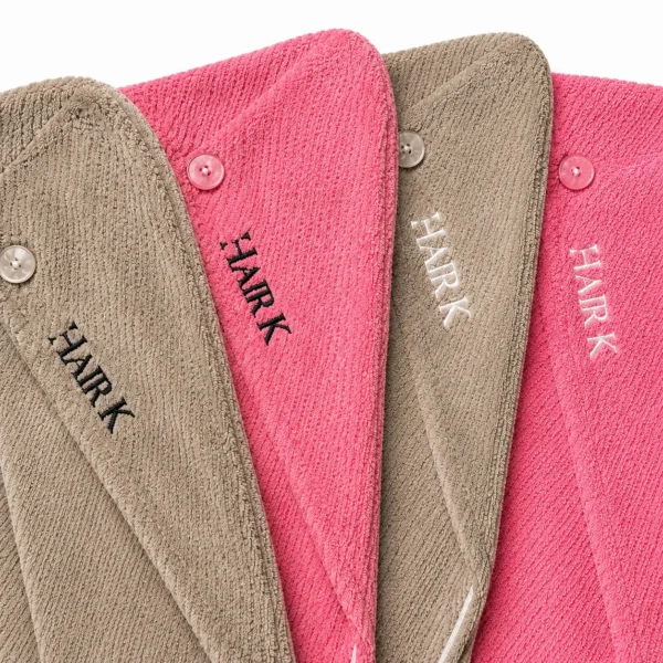 Collection de serviettes microfibres Hair K Paris disponibles en beige et rose, avec logos noir ou blanc, pour un séchage doux et sans frisottis.